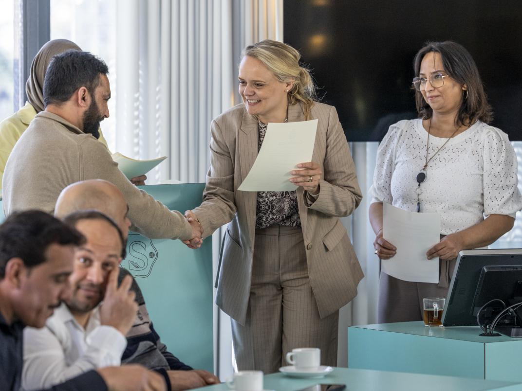 Puck de Nijs-Visser reikt een certificaat uit